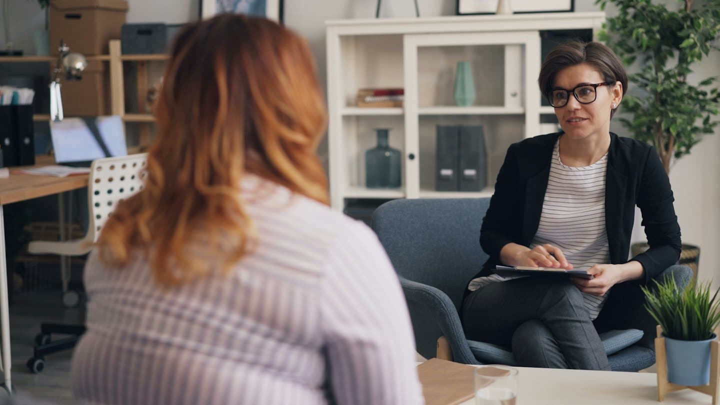 Dos mujeres en una consulta profesional en una oficina luminosa.